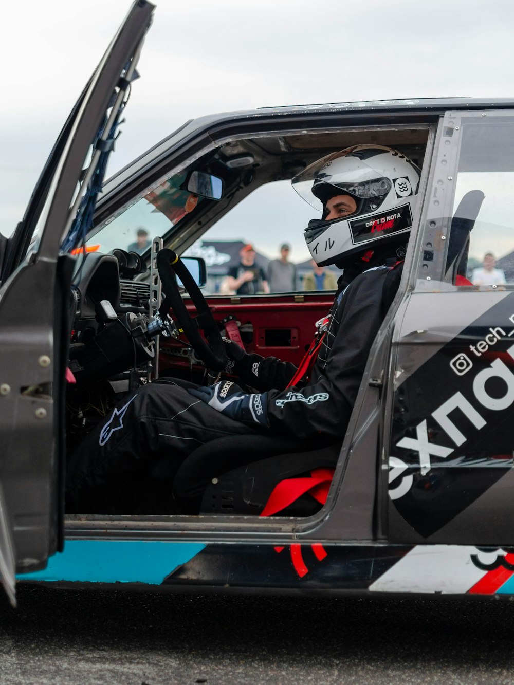 man in black jacket driving a car