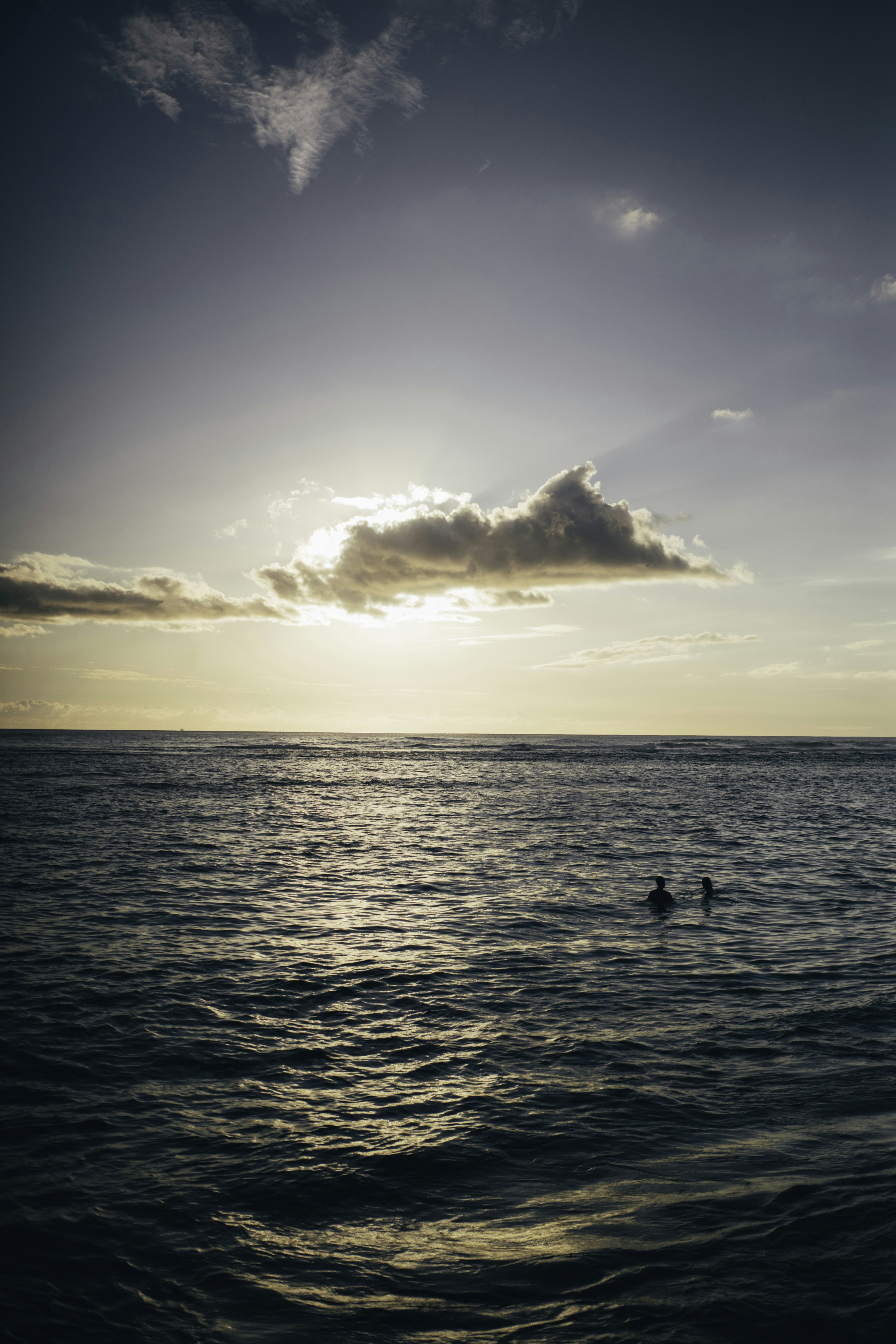 silhouette of person on body of water during sunset
