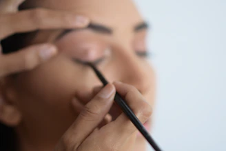 Instructor demonstrating precise eyeliner application on a live model.