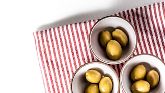 green round fruits on stainless steel bowl