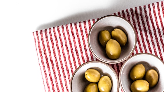 green round fruits on stainless steel bowl