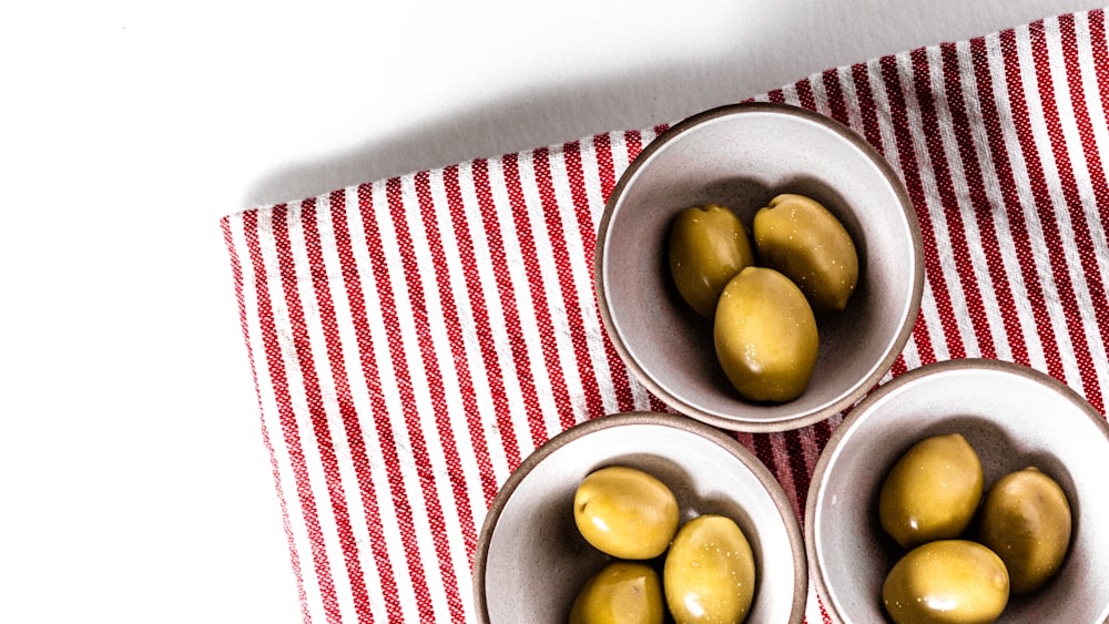 green round fruits on stainless steel bowl