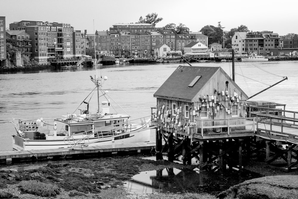 grayscale photo of a house on a dock