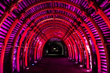 red tunnel with light during night time