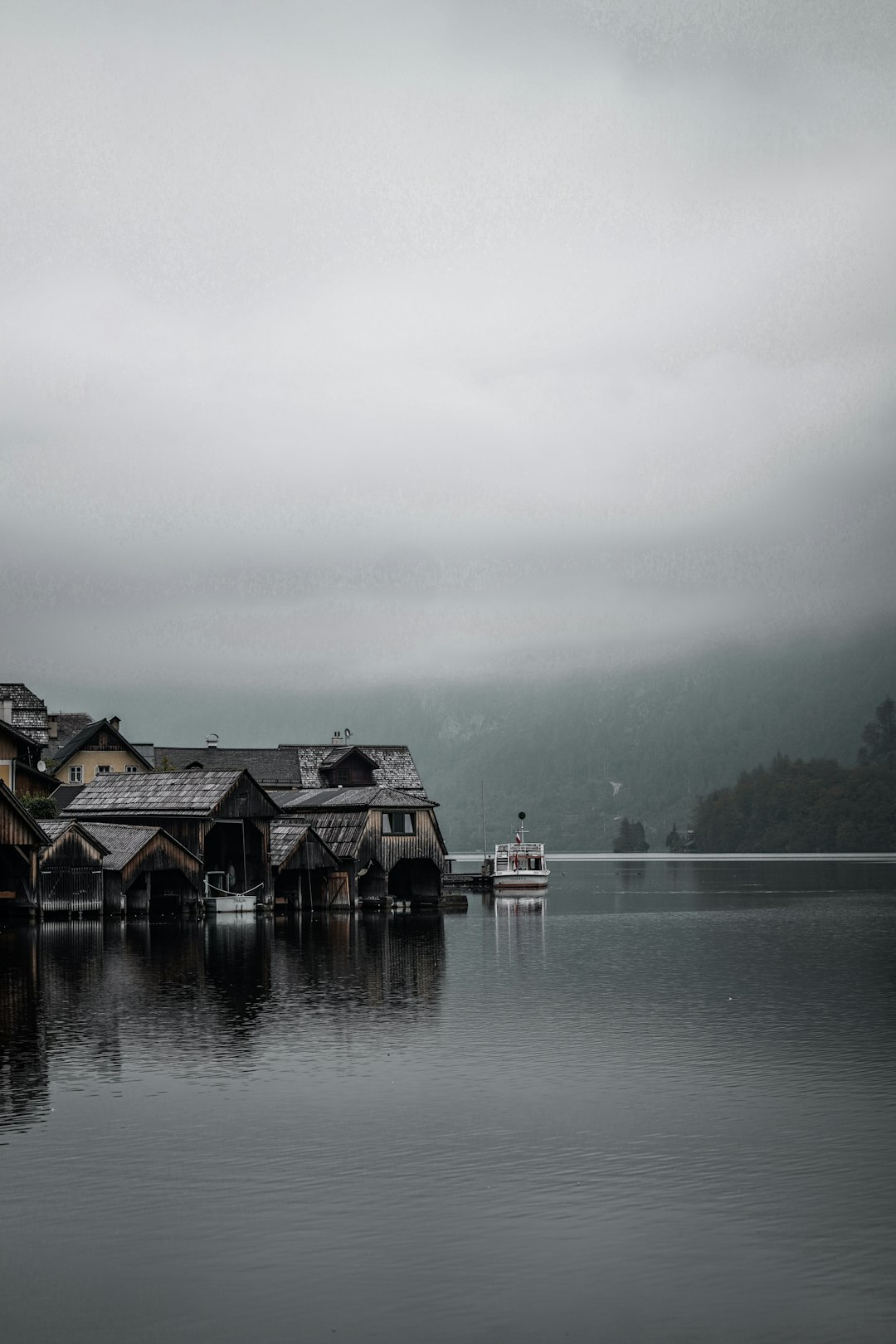 brown wooden house on water under gray sky