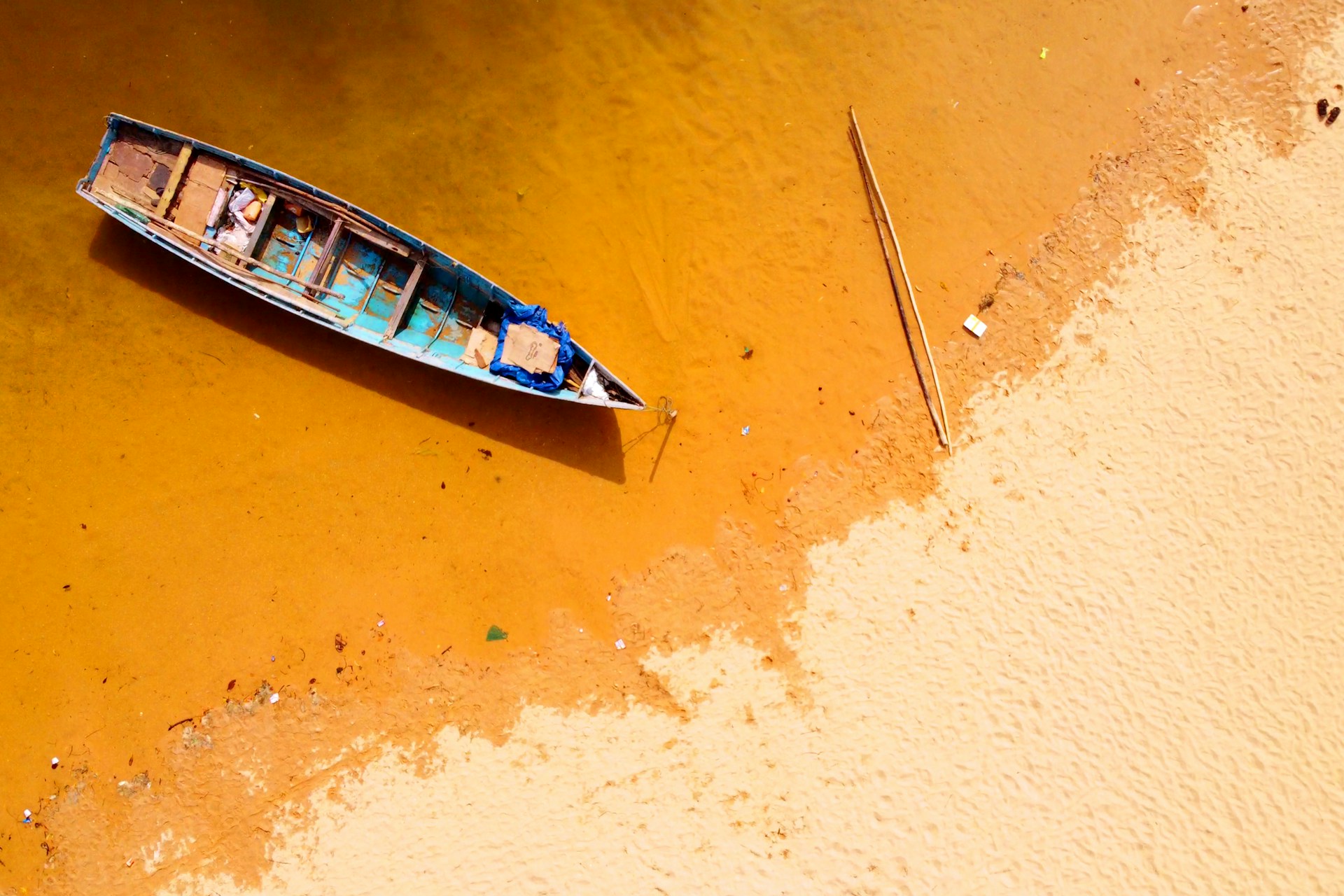white and blue boat on brown sand