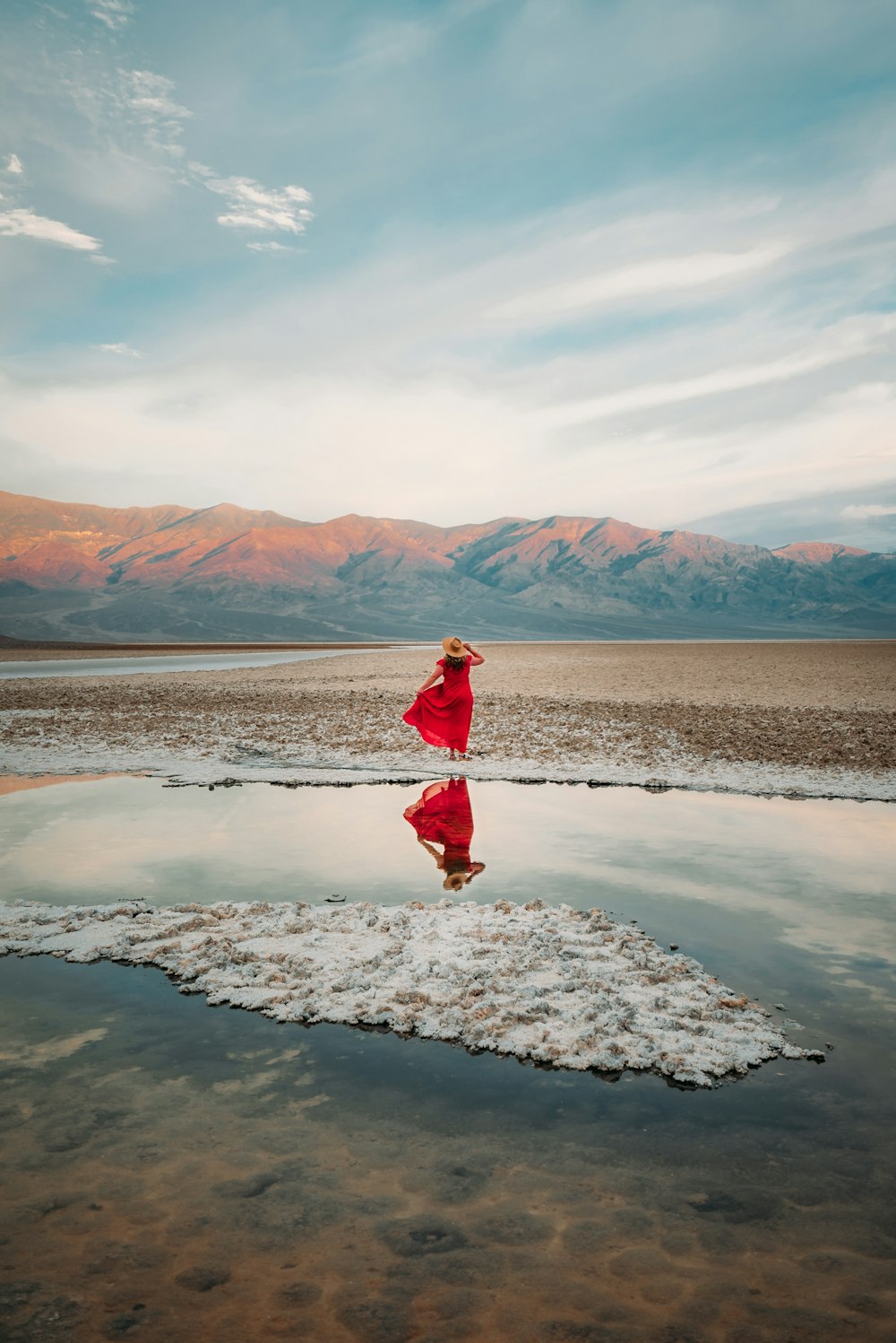 mulher na jaqueta vermelha de pé no chão coberto de neve branca durante o dia