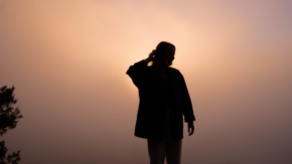 silhouette of man standing and holding camera