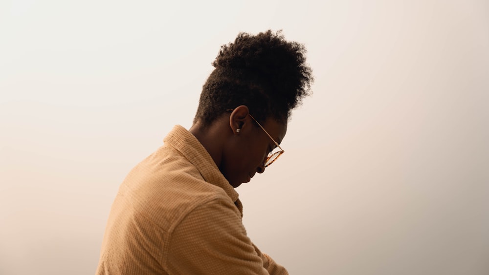 man in brown shirt wearing black framed eyeglasses