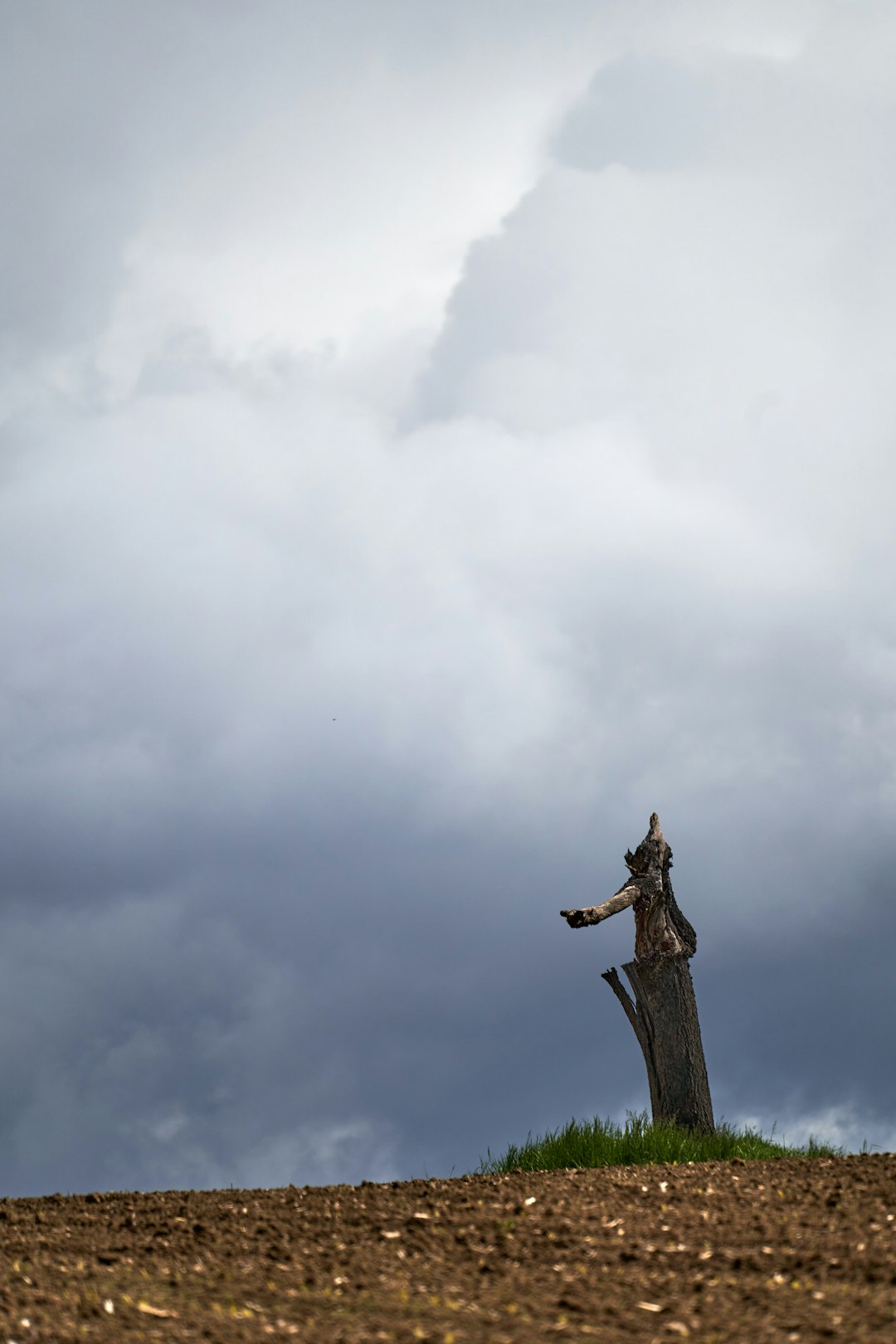 brown wooden cross under white clouds during daytime