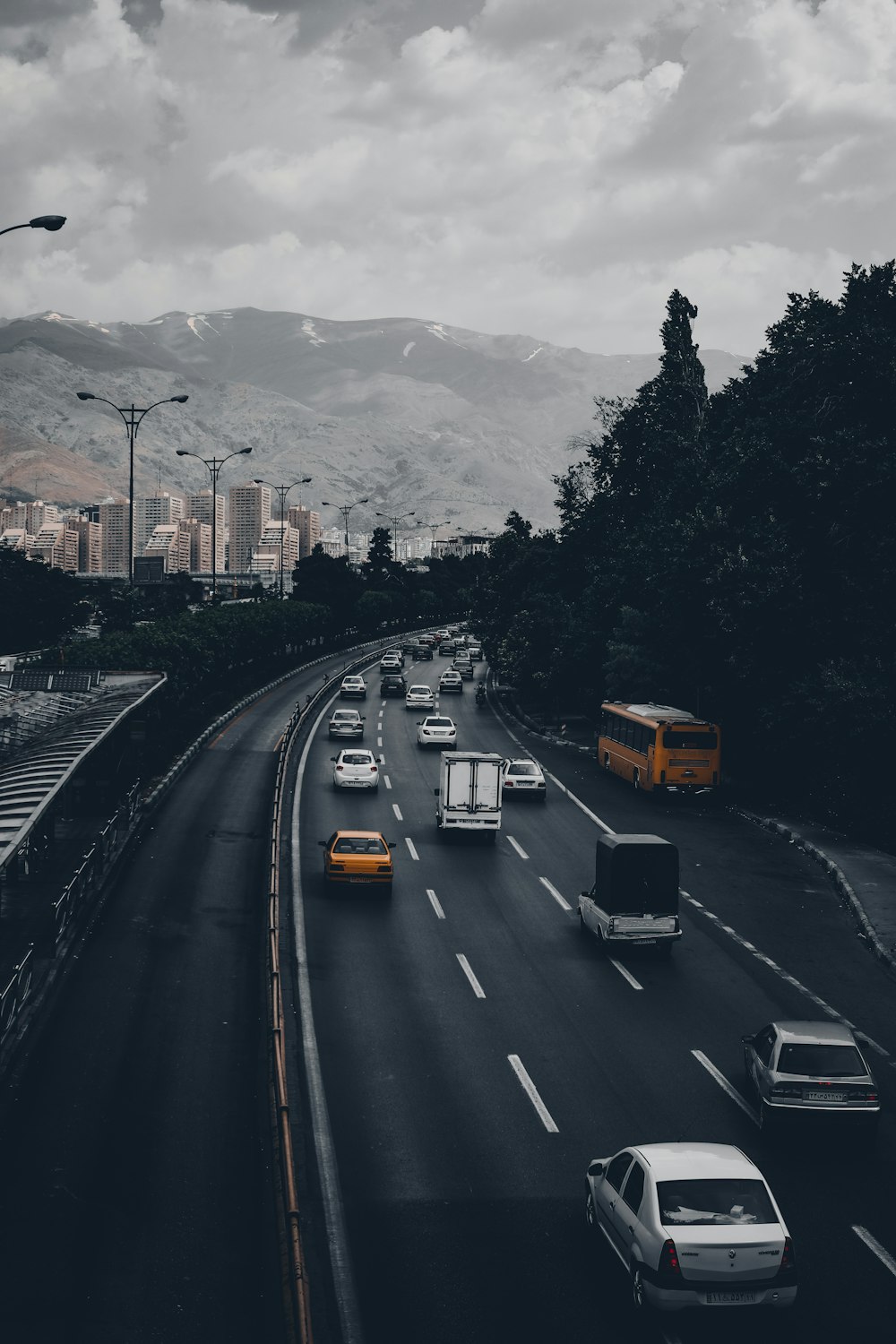 cars on road near trees and mountains during daytime