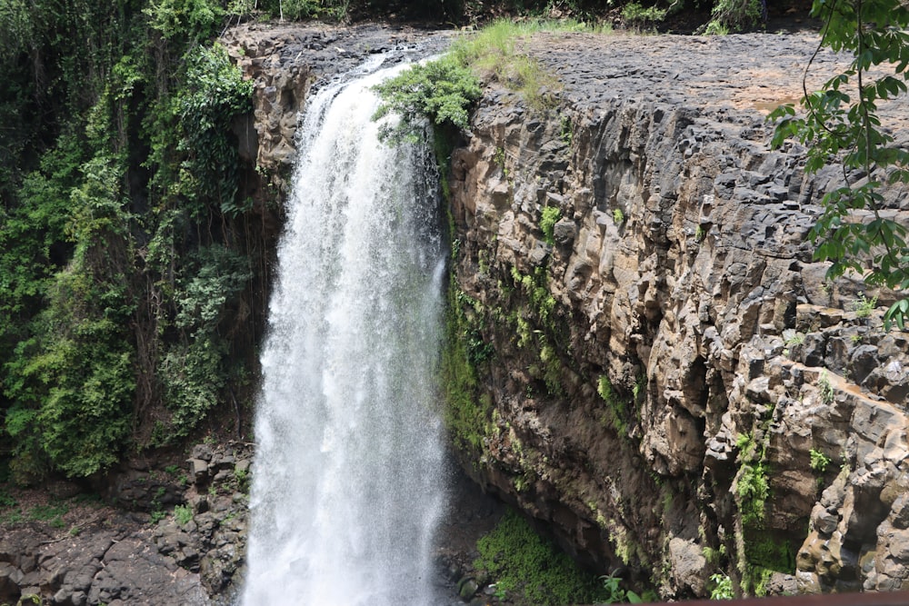 Chutes d’eau sur la montagne rocheuse brune pendant la journée