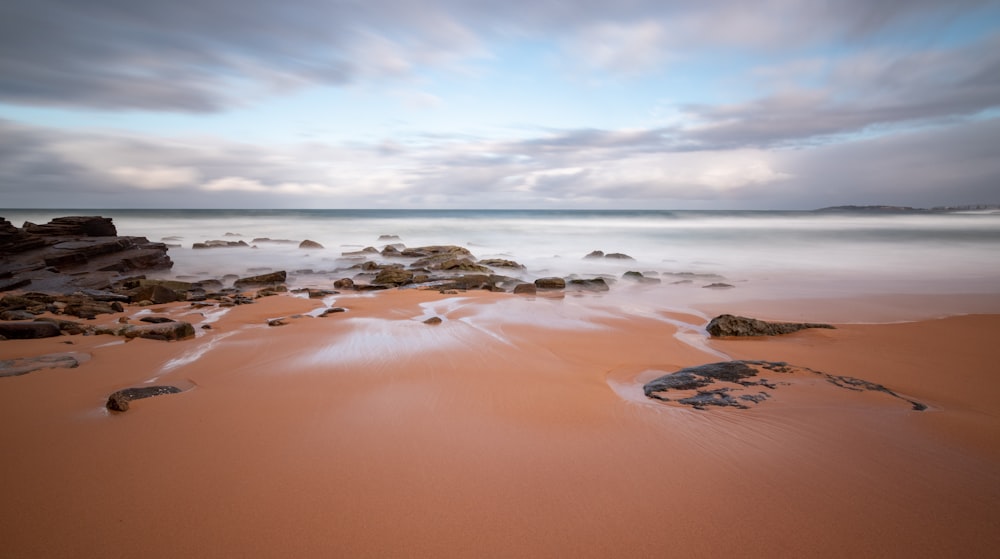 brown sand near body of water during daytime