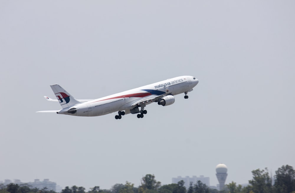 white and red passenger plane flying during daytime