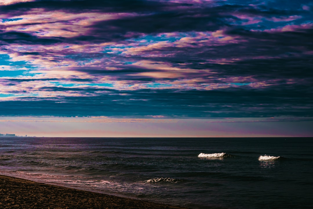 sea waves crashing on shore during sunset