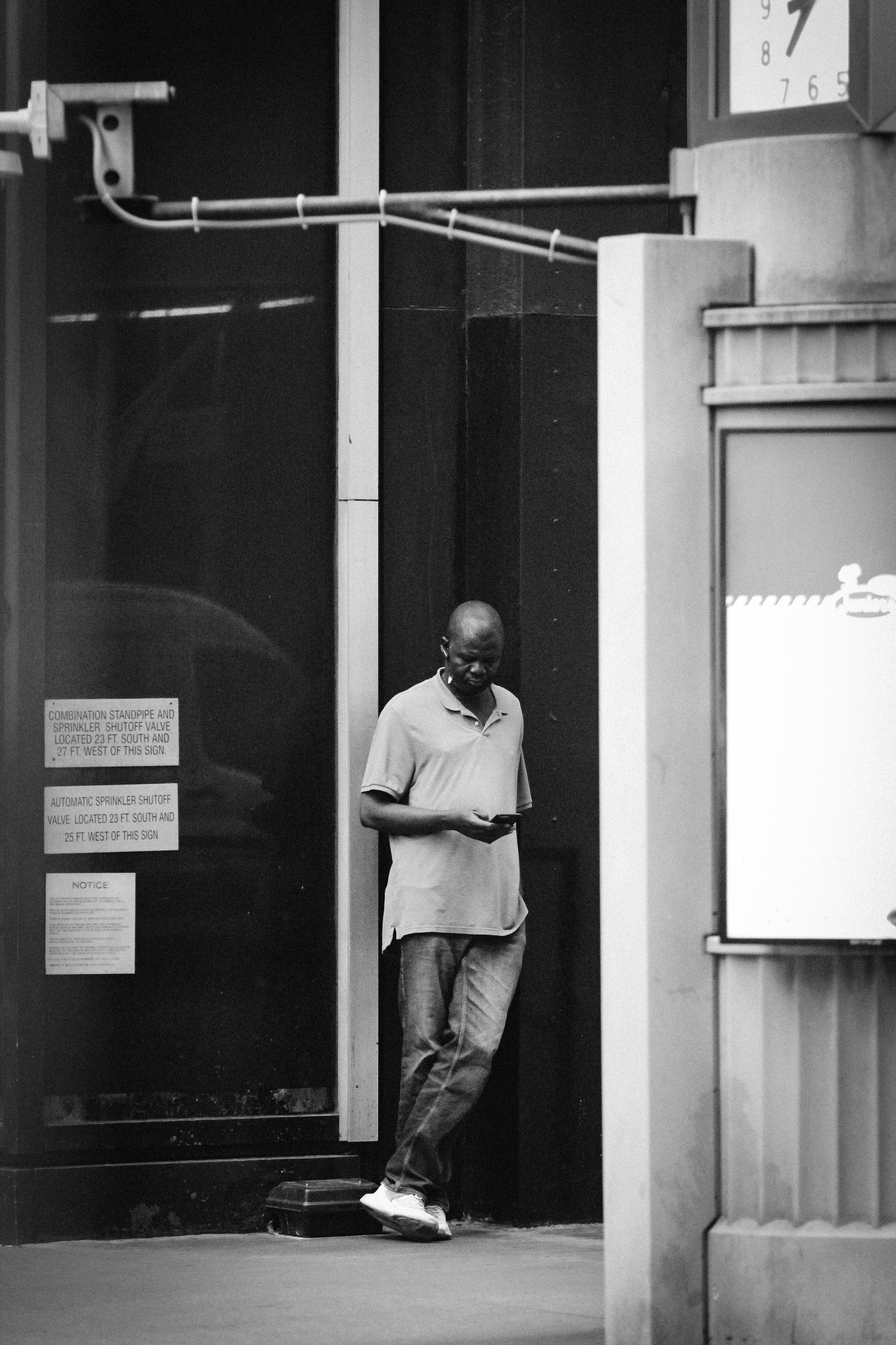 man in white dress shirt and gray pants standing beside glass window