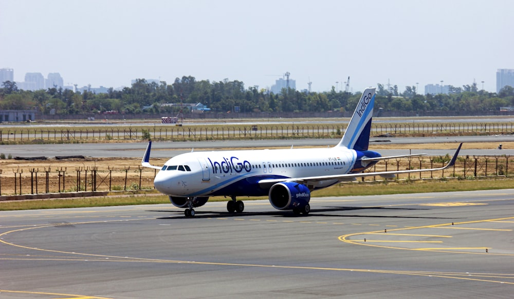 Avión de pasajeros blanco y azul en el aeropuerto durante el día