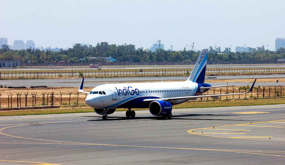 white and blue passenger plane on airport during daytime