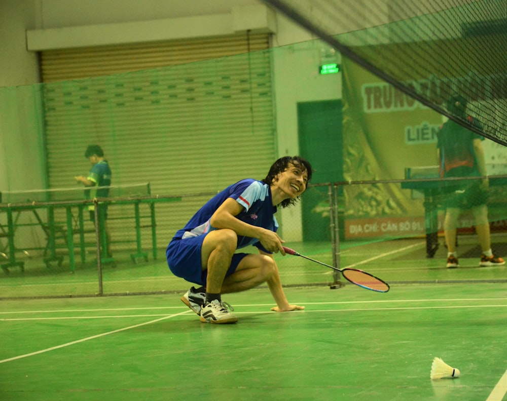 man in blue jersey shirt playing tennis