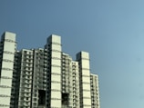 Modern residential building with sleek glass windows under a clear blue sky.