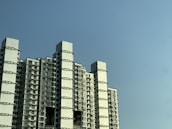 Exterior view of a modern apartment building under a clear blue sky.