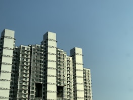 Exterior view of a modern apartment building under a clear blue sky.