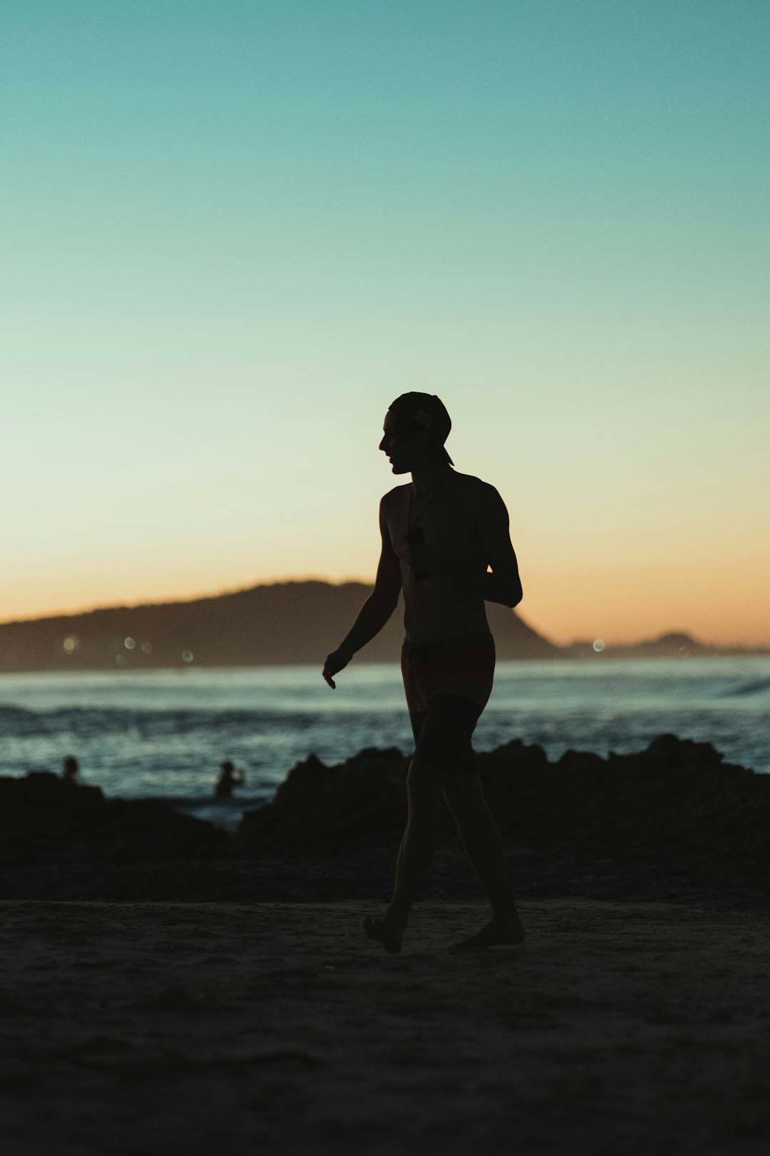 silhouette of man standing on beach during sunset