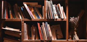 A rustic wooden bookshelf filled with books and plants, highlighting the rich brown wood grain.