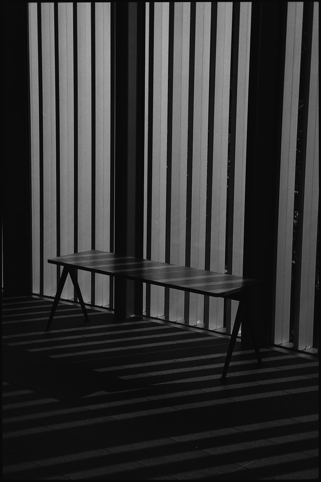 grayscale photo of wooden table and chairs