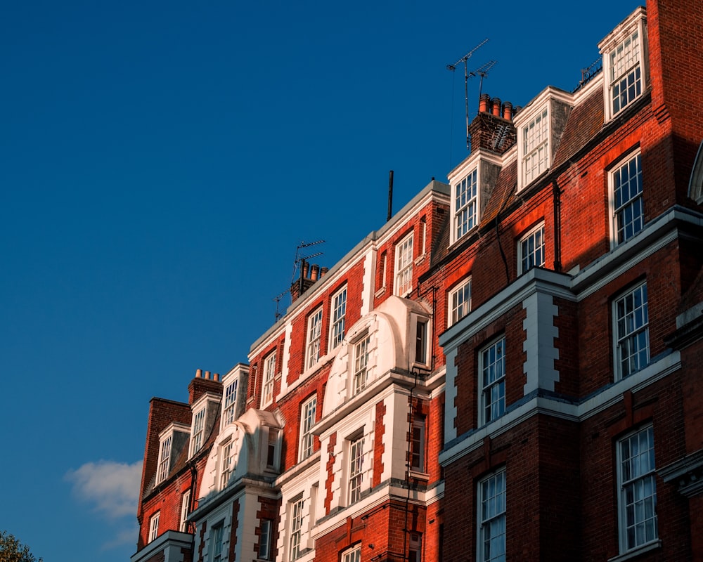 Edificio de hormigón marrón y blanco bajo el cielo azul durante el día