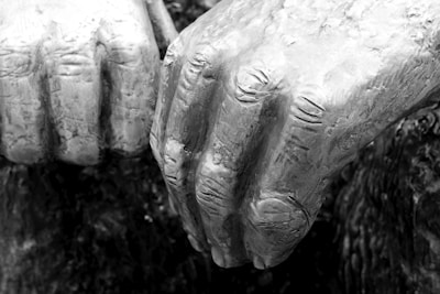 Close-up of weathered hands resting on a stone surface, veins and texture telling stories of resilience.