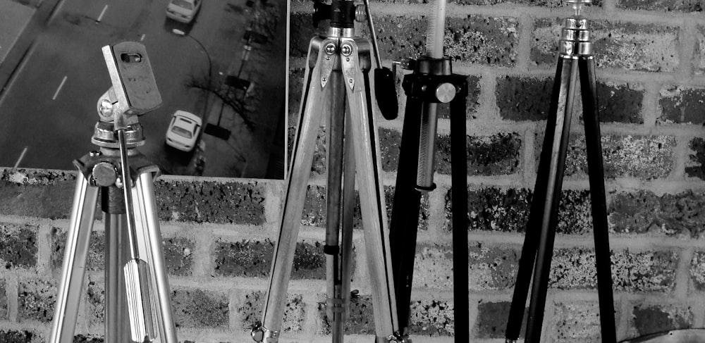 black camera tripod near white wall