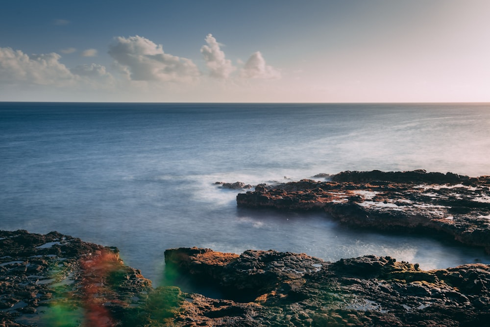 body of water under cloudy sky during daytime