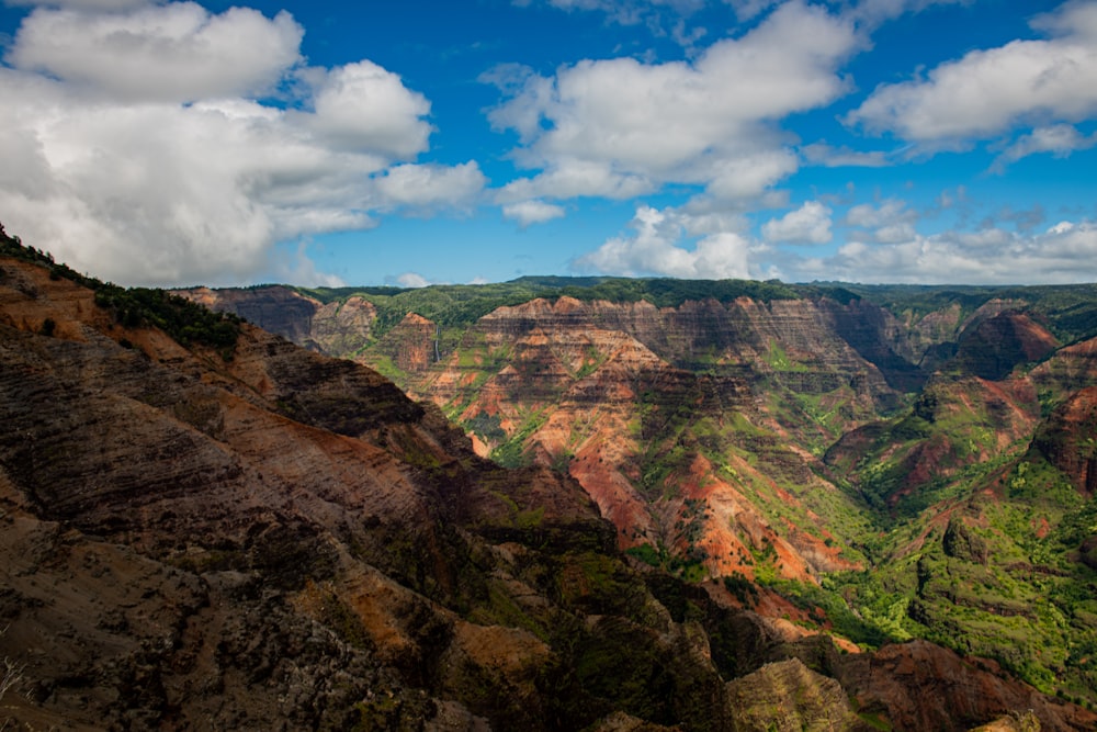 brown and green mountain under blue sky and white clouds during daytime