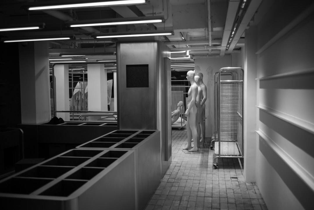 grayscale photo of man walking on hallway