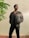 man in black leather jacket standing beside green plant