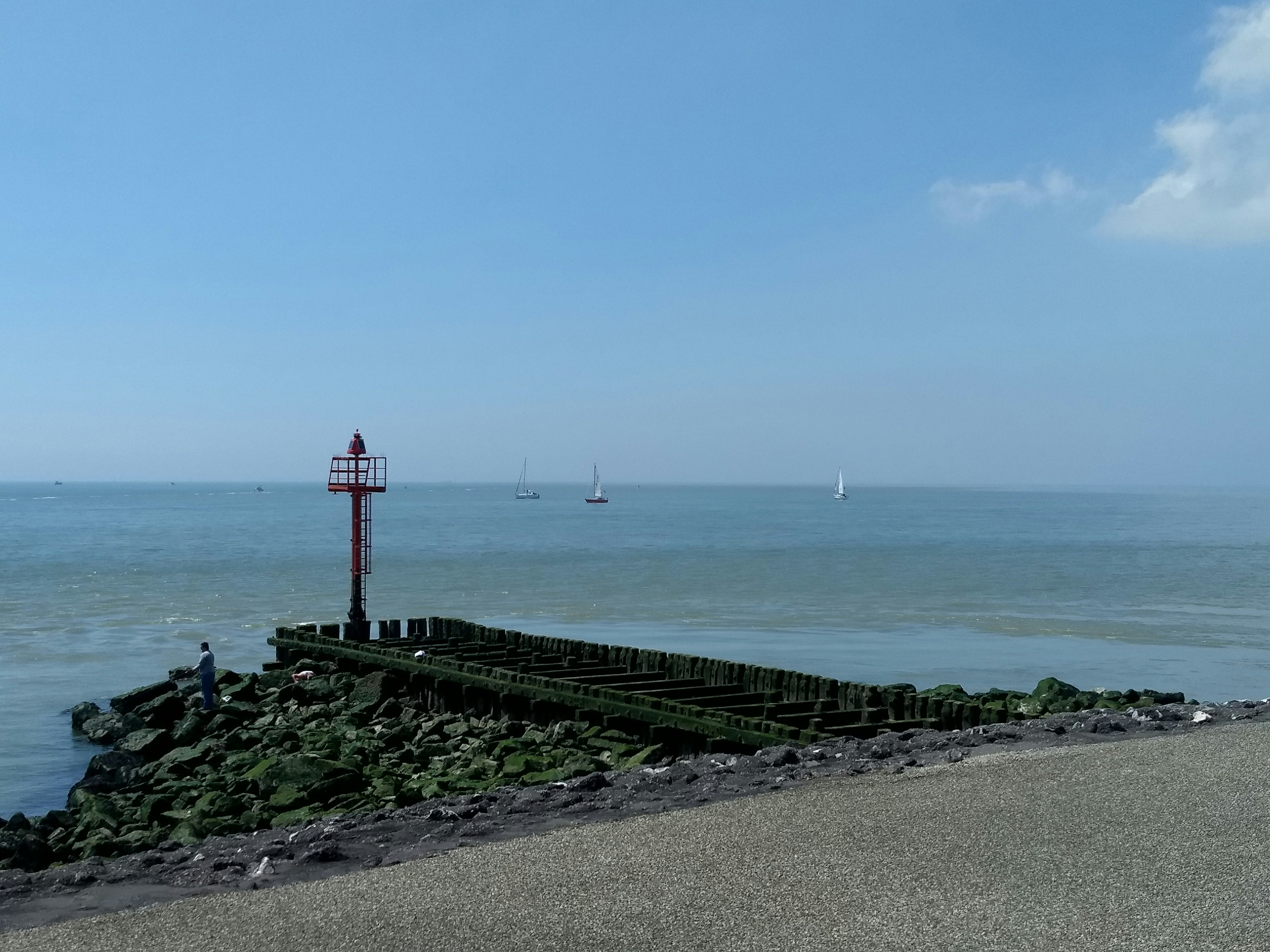 red and white lighthouse near body of water during daytime