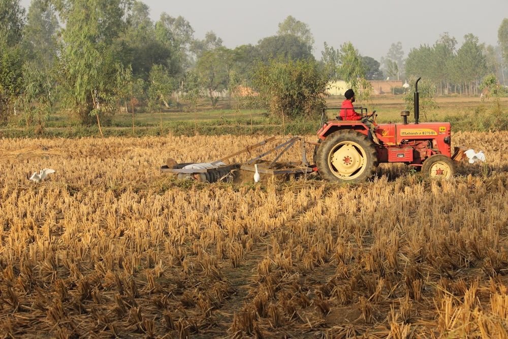 red tractor on brown field during daytime