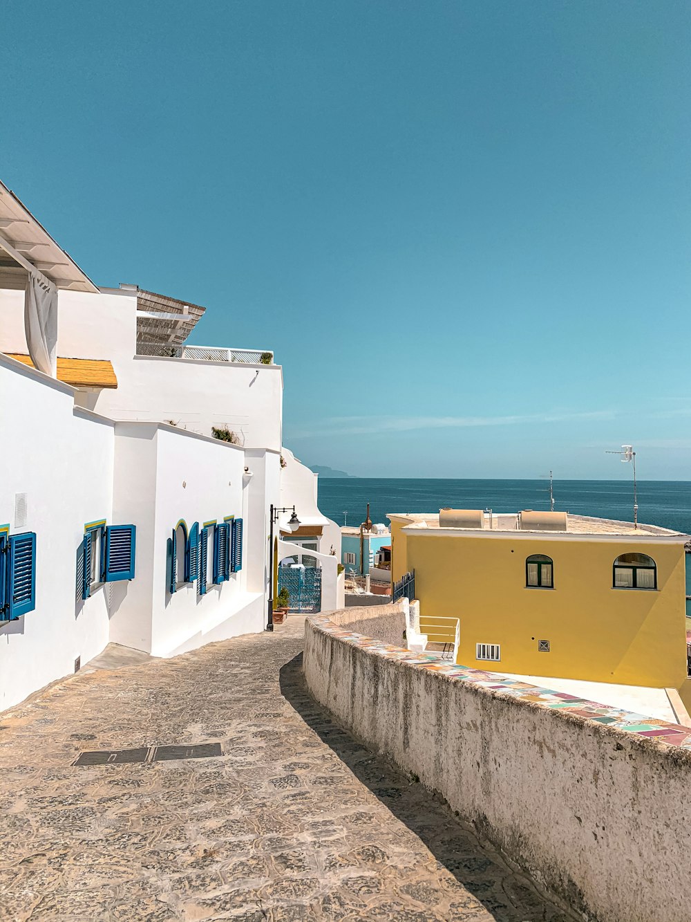 Maisons en béton blanc et bleu près de la mer pendant la journée