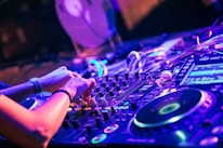 person playing dj controller with purple lights