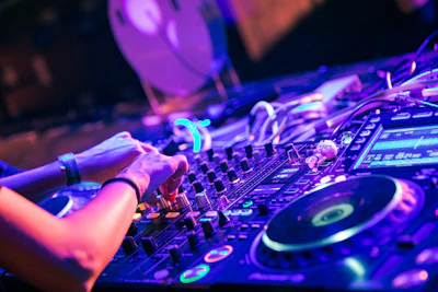 person playing dj controller with purple lights
