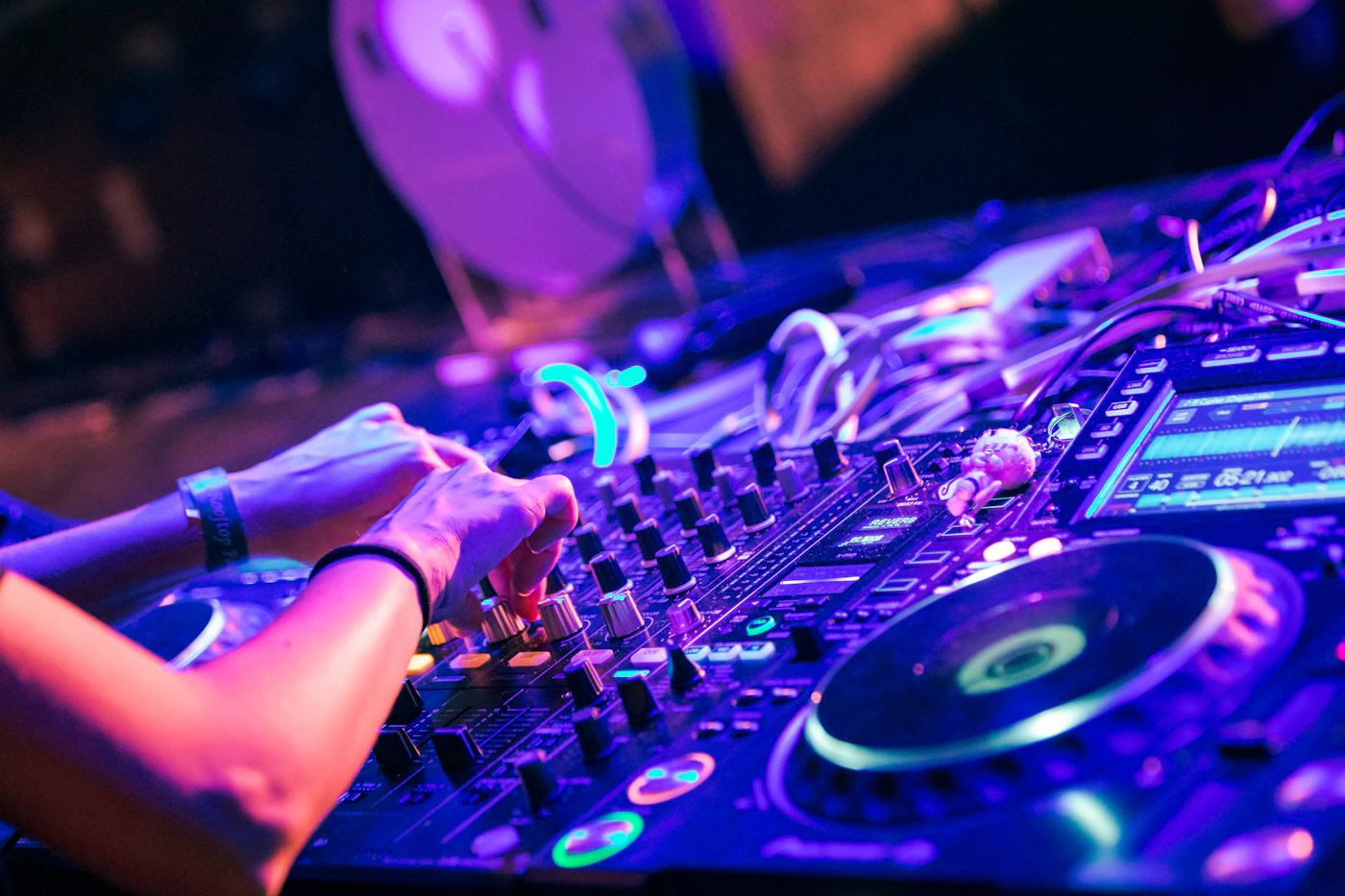 A DJ at the decks under purple light