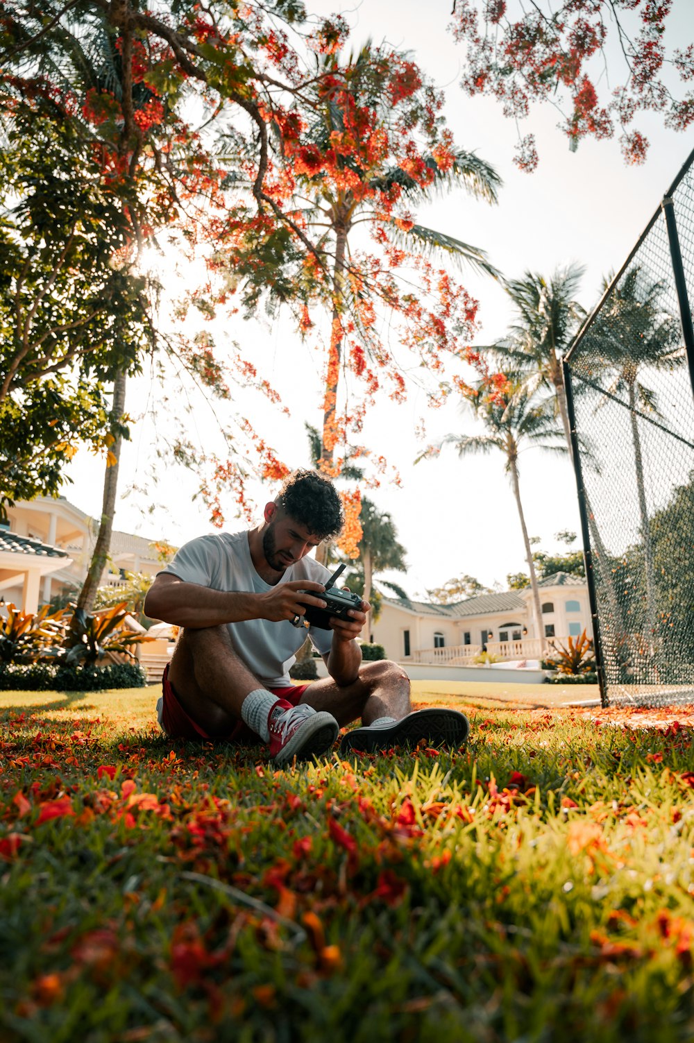 man in white t-shirt sitting on green grass field during daytime