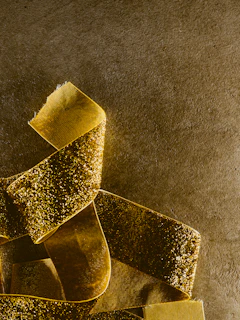 Close-up of a glossy red silk ribbon flowing over a black velvet surface with diamond-like sparkles catching the light