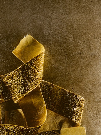 Close-up of a golden ribbon elegantly wrapped around a vibrant red background, highlighting the brand's signature colors.