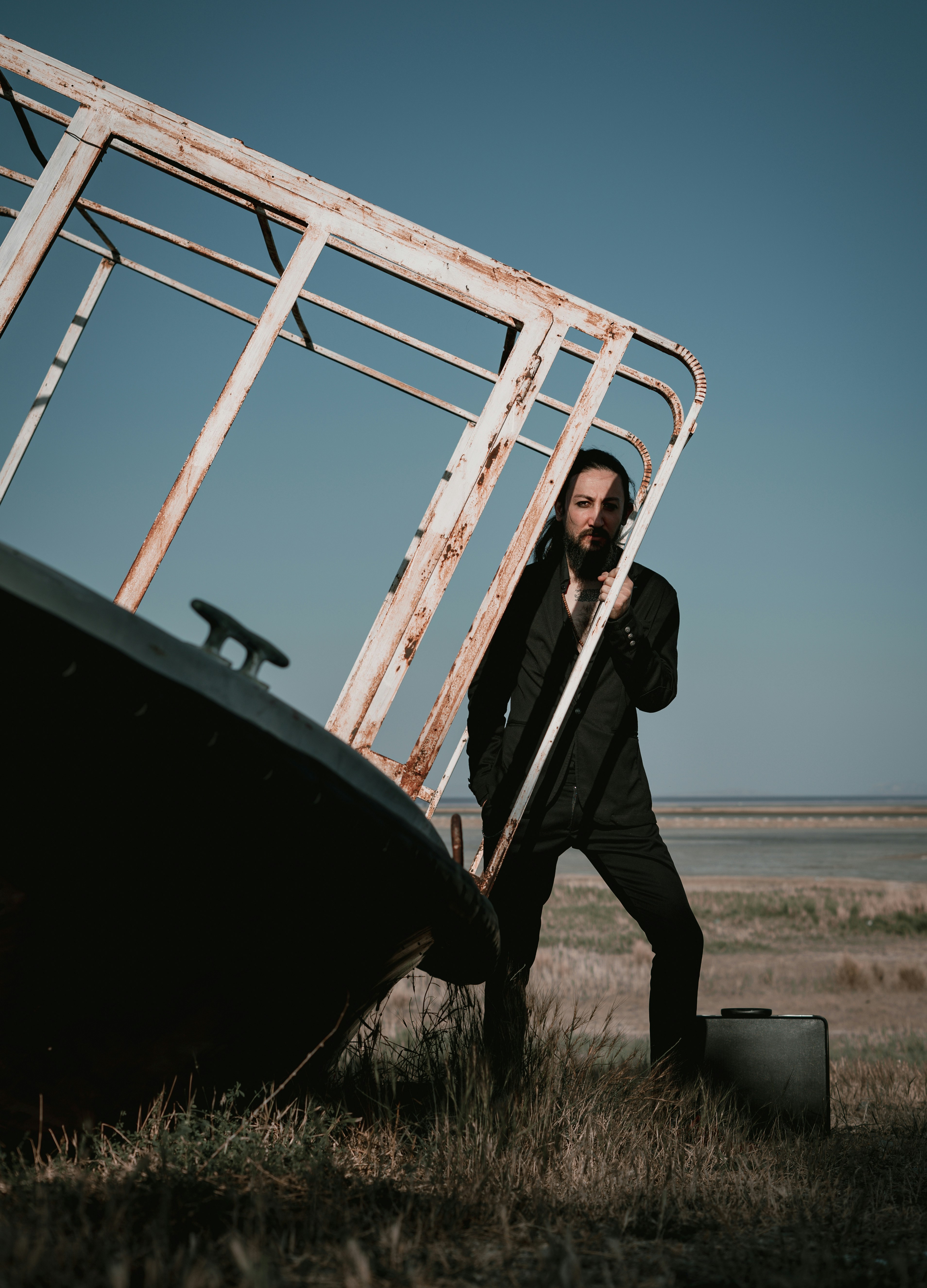 man in black jacket and pants standing on ladder