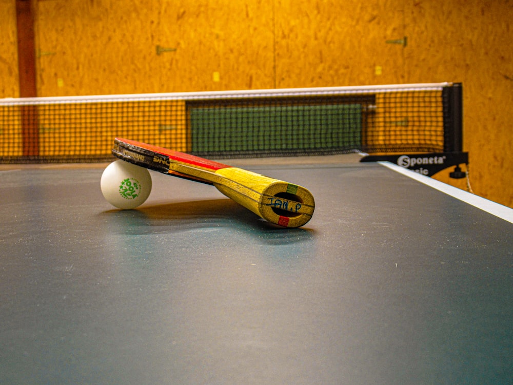 yellow and white tennis racket on green tennis court