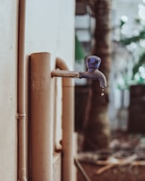 Water dripping from a faucet being repaired by a plumber.