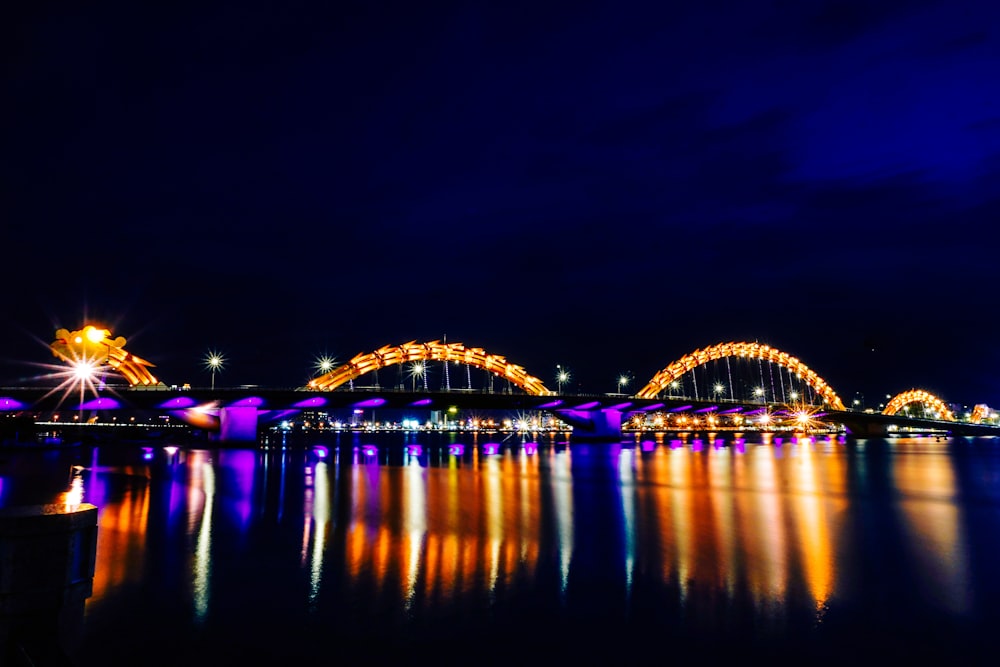 lighted bridge over water during night time