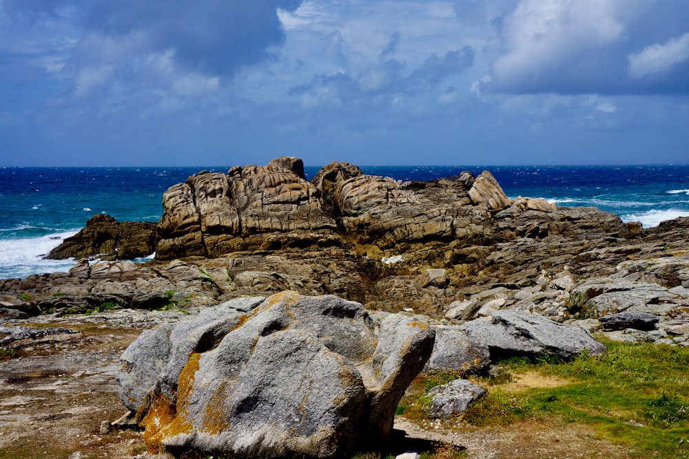 Formación de rocas grises cerca del cuerpo de agua durante el día